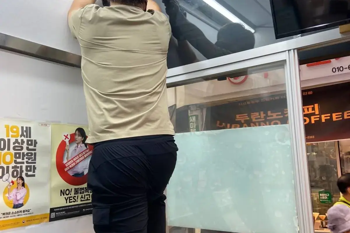 상가 유리 타공 작업 중 위치와 장비를 확인하는 모습