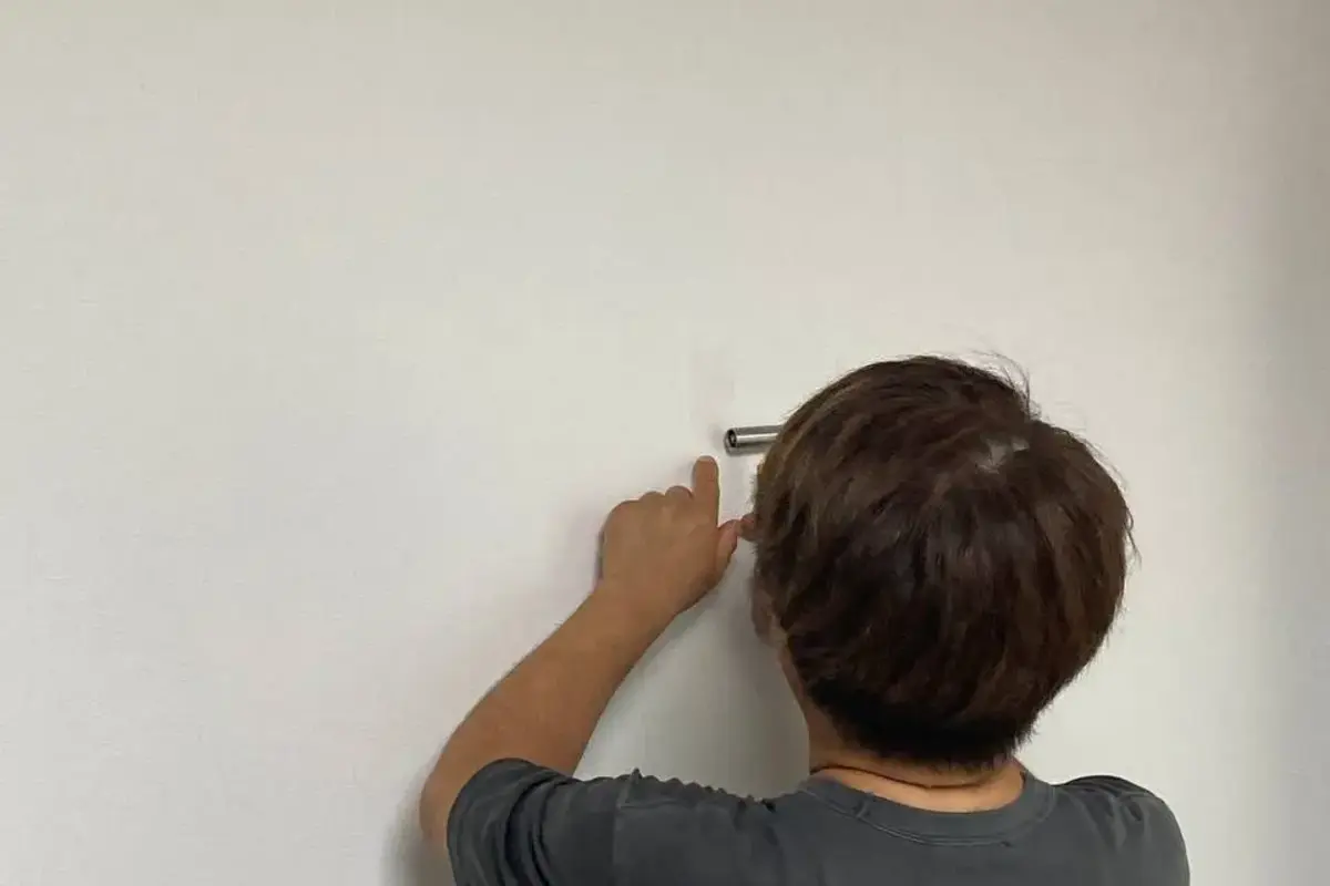손상된 벽지 가장자리를 세밀하게 복원하는 작업 모습
